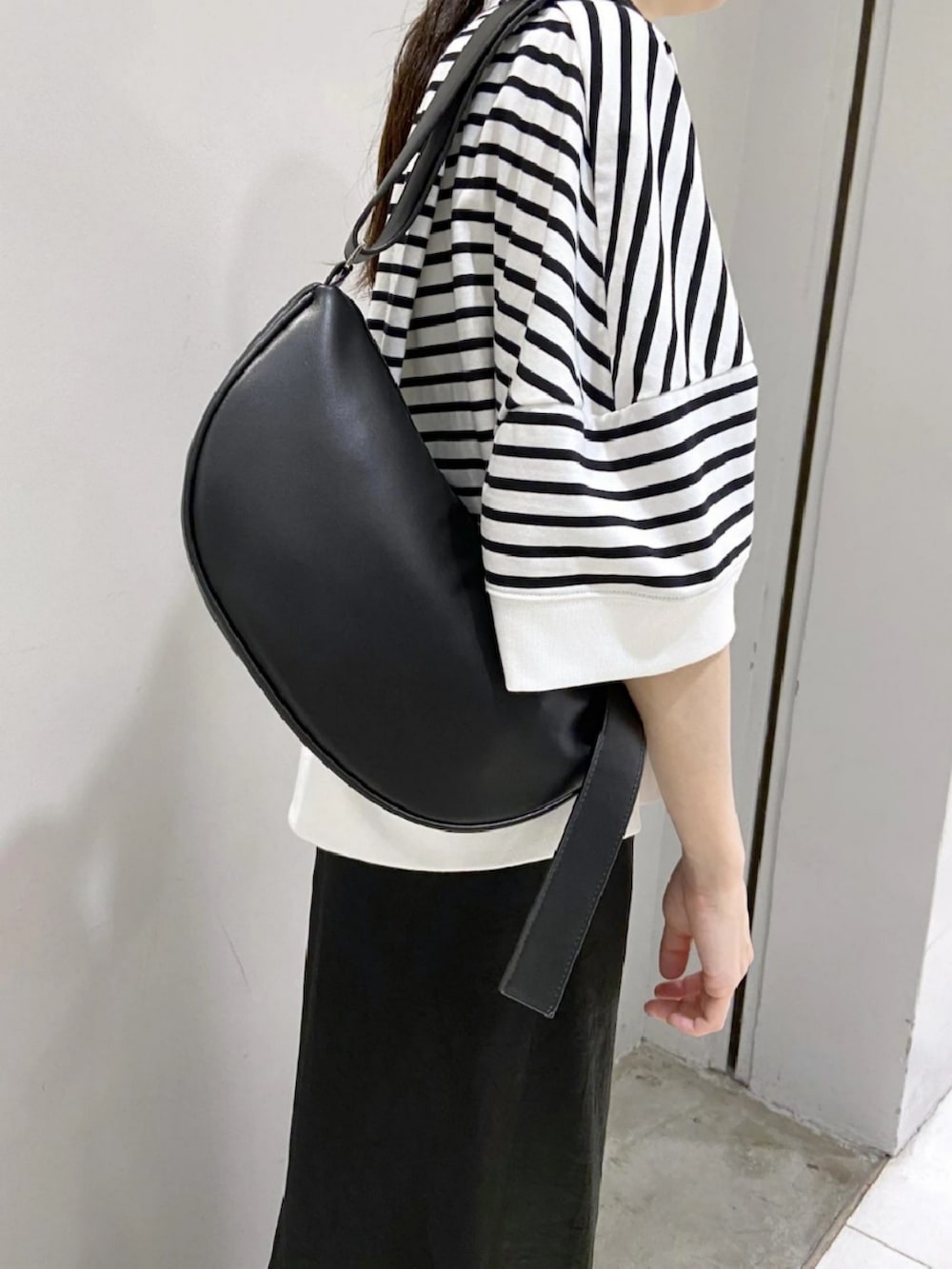 ホワイト系のTシャツ/カットソー、ブラック系のスカート、ブラック系のサンダルを着用したレディースの夏コーディネートの4枚目の写真