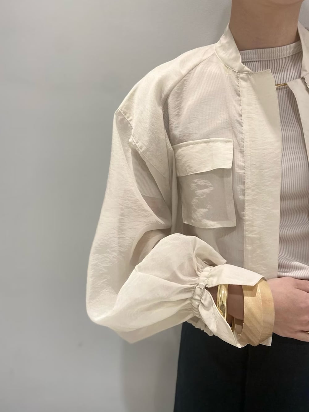 ベージュ系のトートバッグ、ベージュ系のブルゾン、ブラック系のスカートを着用したレディースの春コーディネートの5枚目の写真