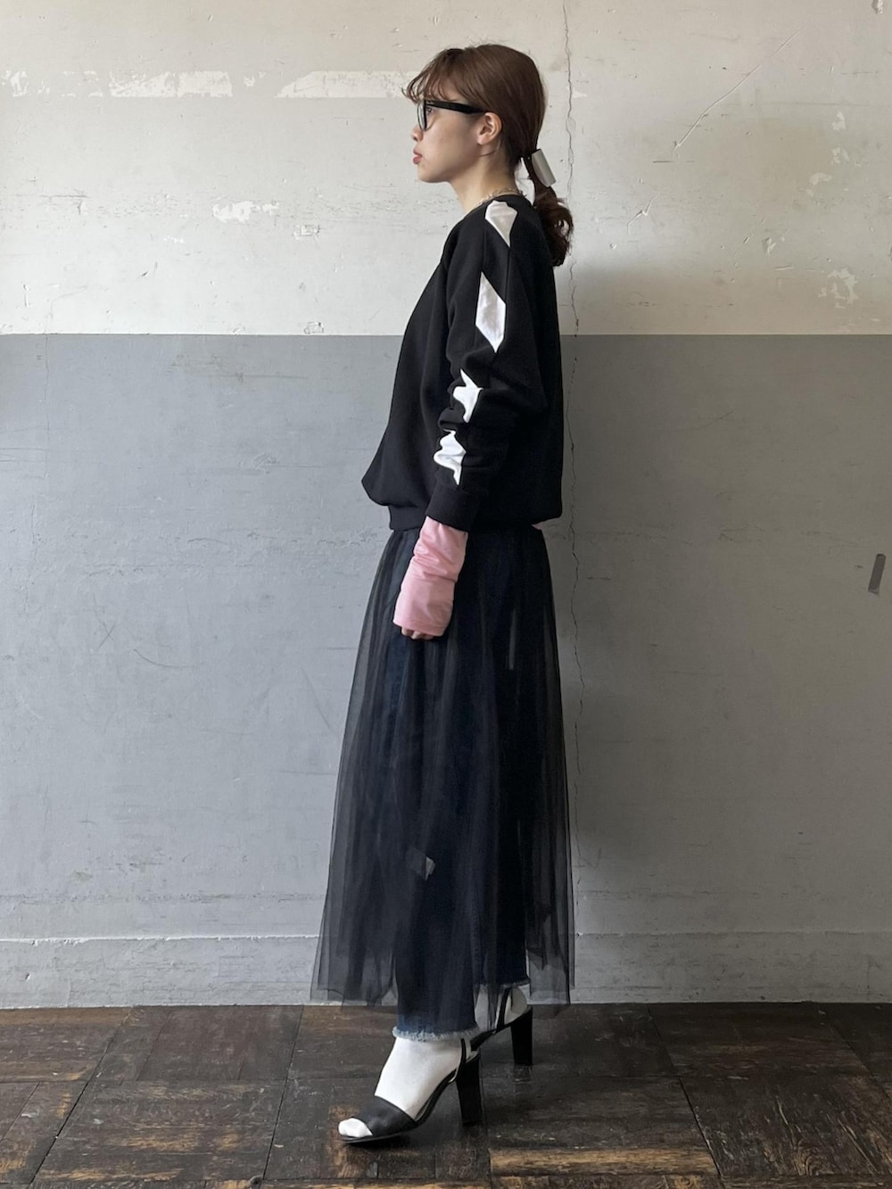 ブラック系のスウェット、ピンク系のTシャツ/カットソー、ブラック系のスカートを着用したレディースの冬コーディネートの2枚目の写真