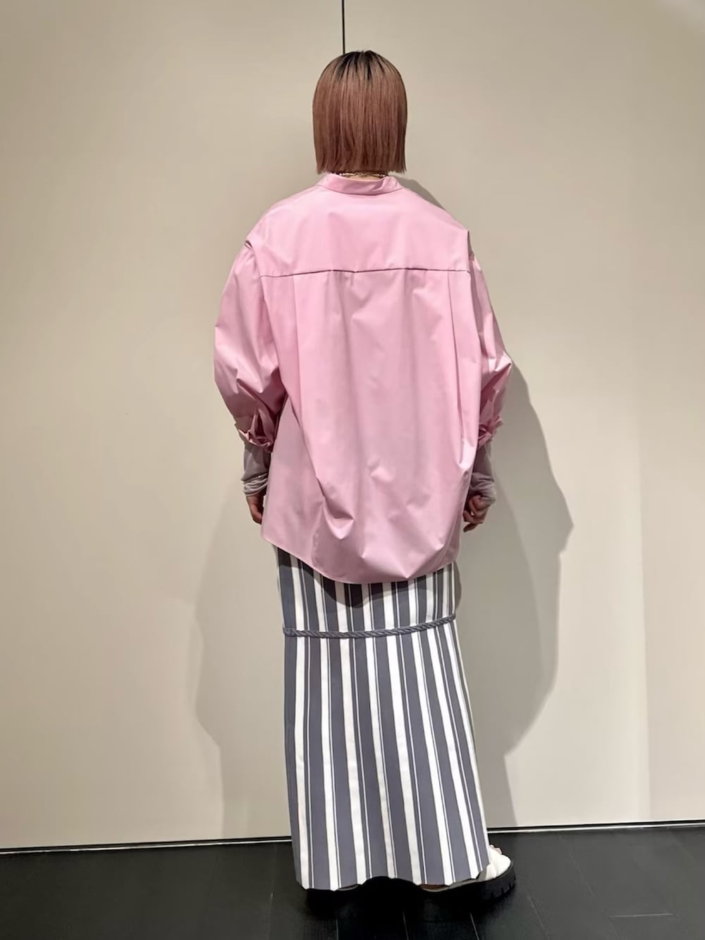 ピンク系のシャツ/ブラウス、グレー系のスカート、ホワイト系のサンダルを着用したレディースの春コーディネートの3枚目の写真