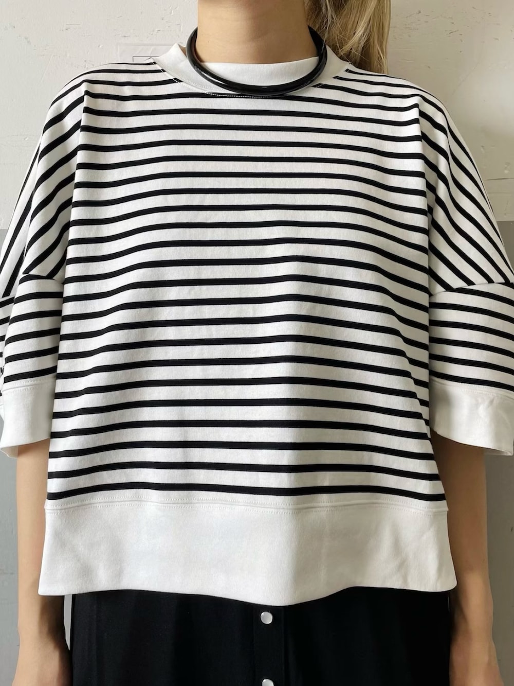 ホワイト系のTシャツ/カットソー、ブラック系のスカート、ブラック系のサンダルを着用したレディースの春コーディネートの5枚目の写真