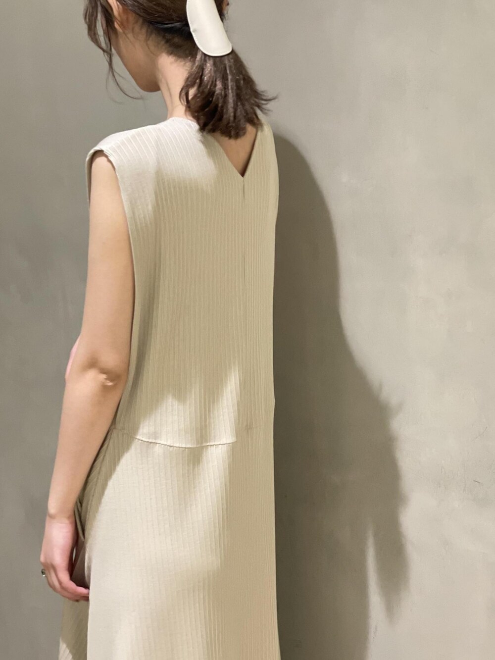 ホワイト系のテーラードジャケット、ベージュ系のワンピース、オレンジ系のサンダルを着用したレディースの春コーディネートの3枚目の写真