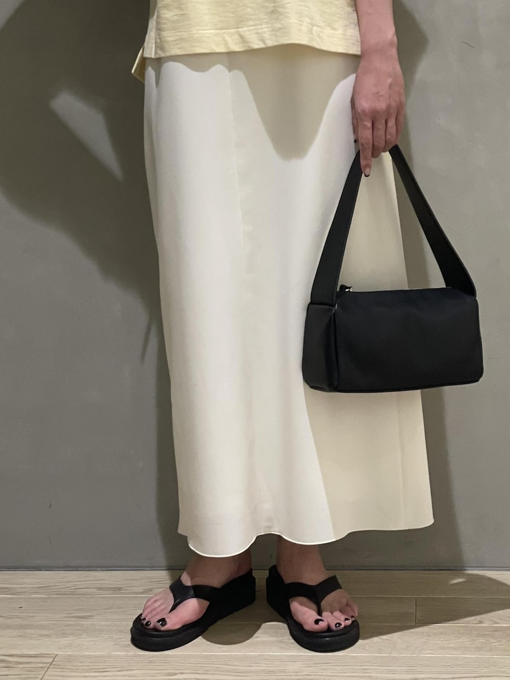 ホワイト系のワンピース、ベージュ系のTシャツ/カットソー、ブラック系のサンダルを着用したレディースの夏コーディネートの4枚目の写真