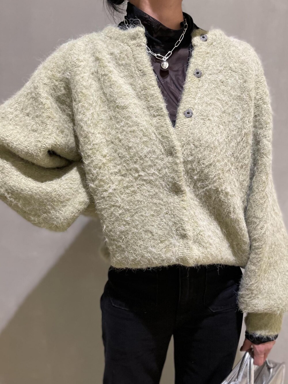 グリーン系のカーディガン/ボレロ、ブラック系のTシャツ/カットソー、シルバー系のショルダーバッグを着用したレディースの夏コーディネートの3枚目の写真