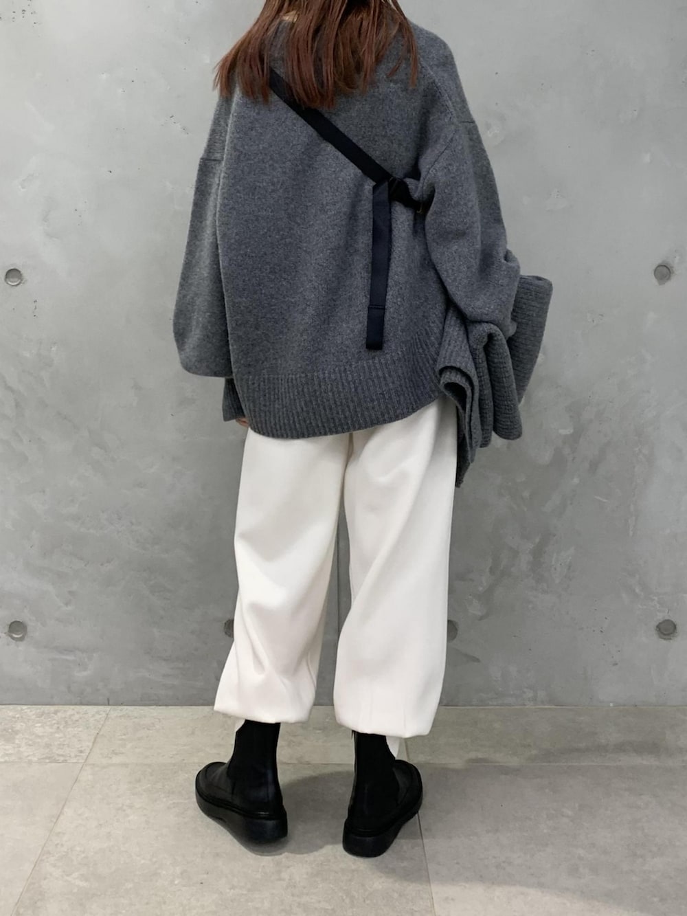 グレー系のニット/セーター、ベージュ系のボディバッグ/ウエストポーチ、ホワイト系のその他パンツを着用したレディースの秋コーディネートの3枚目の写真