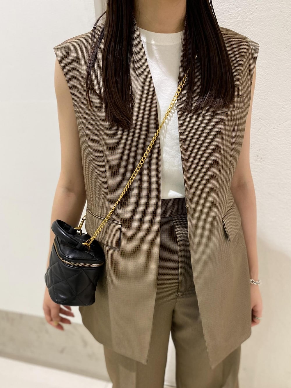 ブラウン系のその他アウター、ブラック系のショルダーバッグ、ブラウン系のスラックスを着用したレディースの夏コーディネートの2枚目の写真