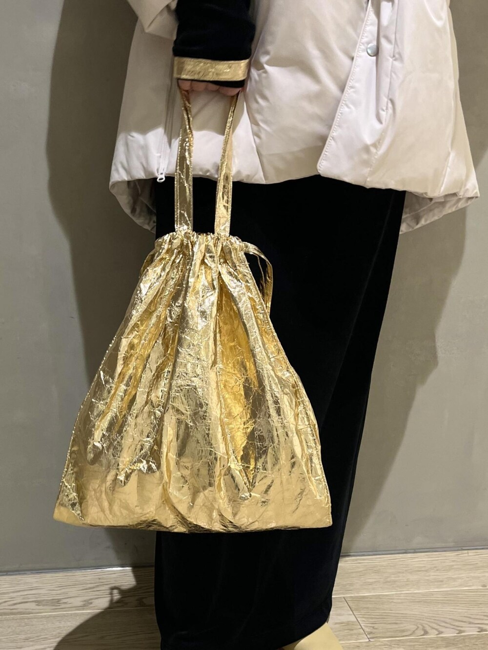 ホワイト系のダウンジャケット/コート、ベージュ系のブーツ、ゴールド系のエコバッグ/サブバッグを着用したレディースの冬コーディネートの5枚目の写真