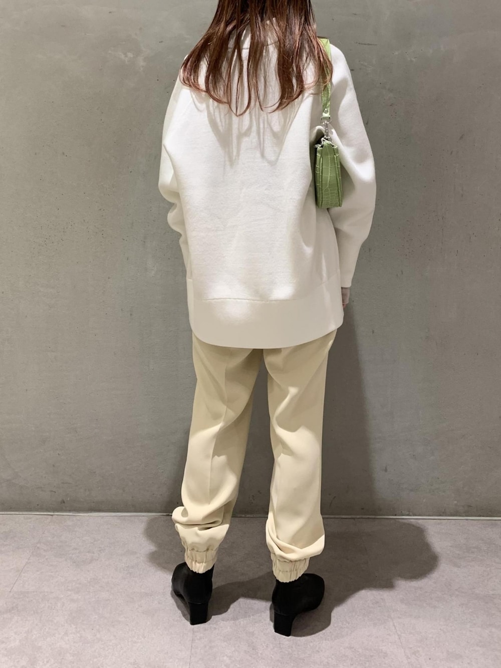 ホワイト系のカーディガン/ボレロ、グリーン系のハンドバッグ、ベージュ系のその他パンツを着用したレディースの冬コーディネートの2枚目の写真