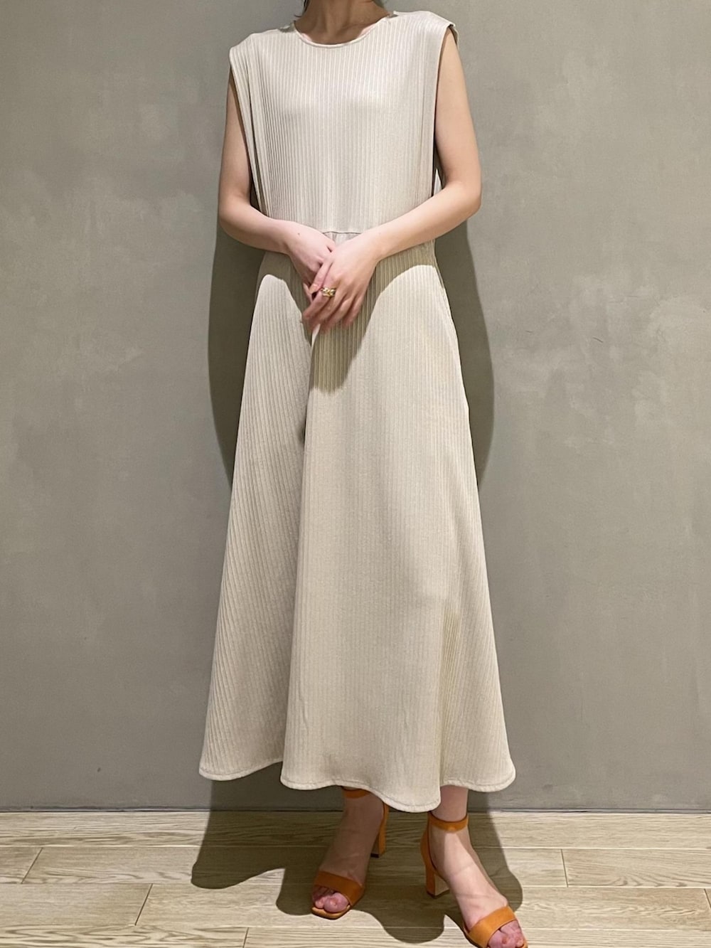 ホワイト系のテーラードジャケット、ベージュ系のワンピース、オレンジ系のサンダルを着用したレディースの春コーディネートの5枚目の写真