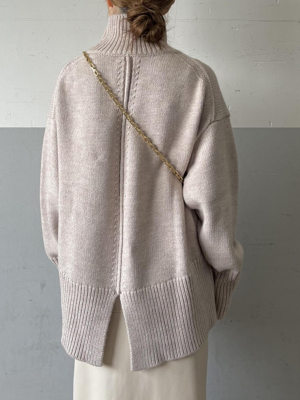 ベージュ系のニット/セーター、イエロー系のショルダーバッグ、ホワイト系のスカートを着用したレディースの夏コーディネートの4枚目の写真