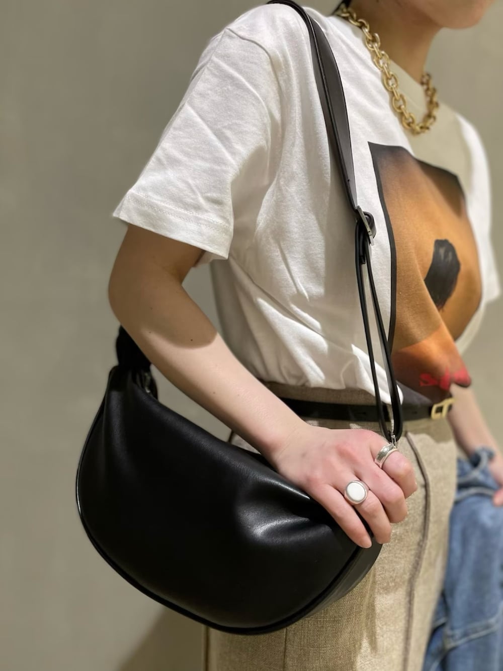 ホワイト系のTシャツ/カットソー、ベージュ系のスカート、ブラック系のサンダルを着用したレディースの春コーディネートの4枚目の写真