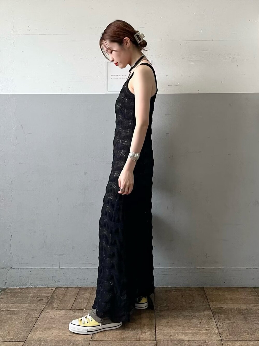 ブラック系のワンピース、イエロー系のスニーカーを着用したレディースの春コーディネートの2枚目の写真