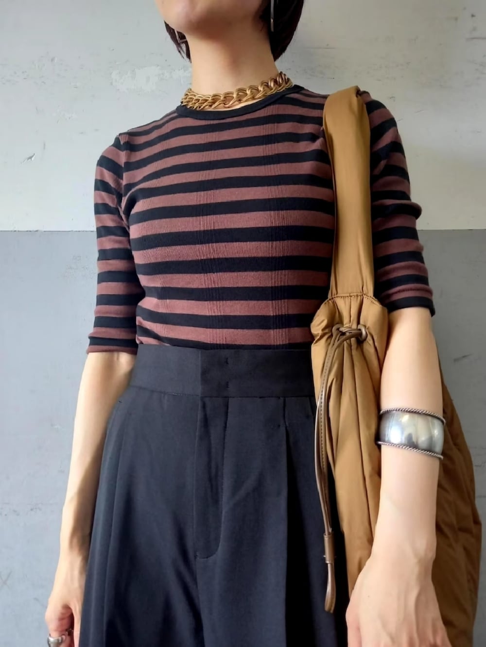 ブラック系のパンプス、ブラック系のスラックス、ブラウン系のTシャツ/カットソーを着用したレディースの秋コーディネートの3枚目の写真