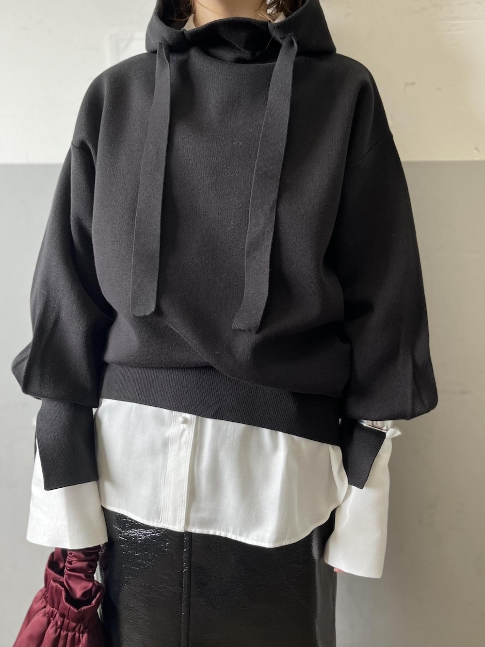 ブラック系のニット/セーター、ホワイト系のシャツ/ブラウス、ブラック系のスカートを着用したレディースの秋コーディネートの3枚目の写真