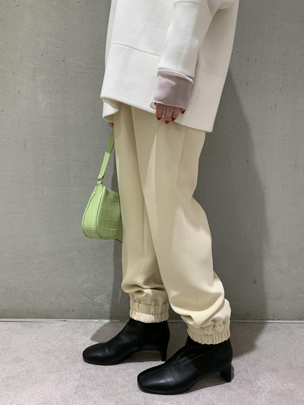 ホワイト系のカーディガン/ボレロ、グリーン系のハンドバッグ、ベージュ系のその他パンツを着用したレディースの冬コーディネートの5枚目の写真