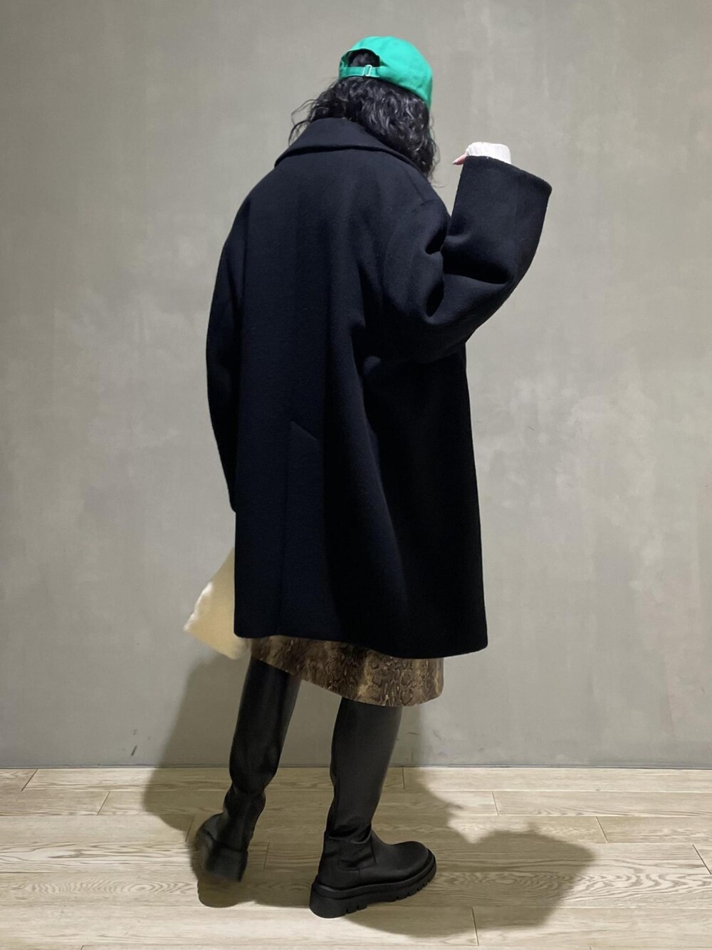 ブラック系のその他アウター、ホワイト系のニット/セーター、ホワイト系のハンドバッグを着用したレディースの冬コーディネートの3枚目の写真