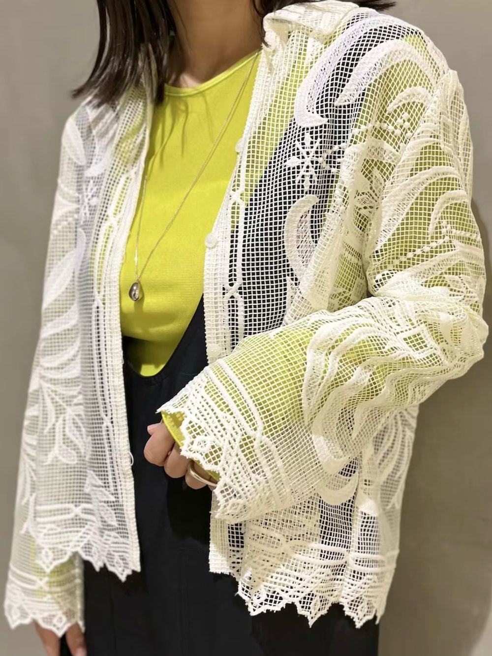 ホワイト系のシャツ/ブラウス、グリーン系のTシャツ/カットソー、ブラック系のサロペット/オーバーオールを着用したレディースの春コーディネートの4枚目の写真