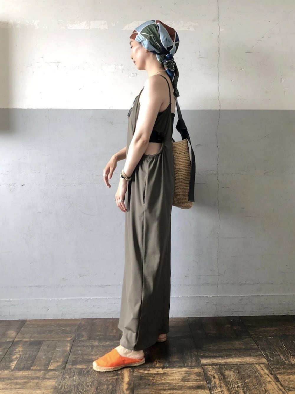 グリーン系のワンピース、ブラック系のチューブトップを着用したレディースの夏コーディネートの2枚目の写真