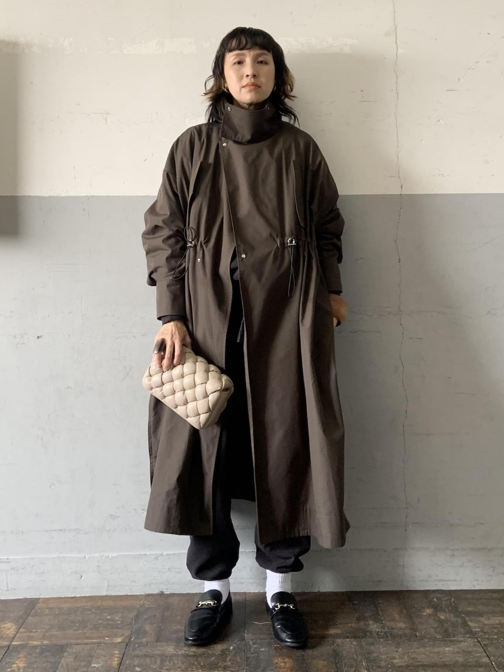 ブラック系のローファー、グリーン系のモッズコート、ベージュ系のショルダーバッグを着用したレディースの冬コーディネートの2枚目の写真