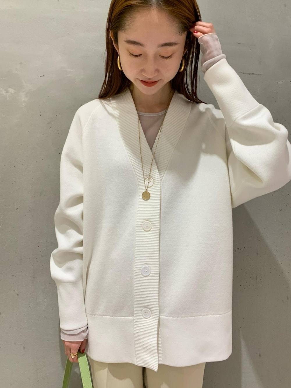 ホワイト系のカーディガン/ボレロ、グリーン系のハンドバッグ、ベージュ系のその他パンツを着用したレディースの冬コーディネートの4枚目の写真