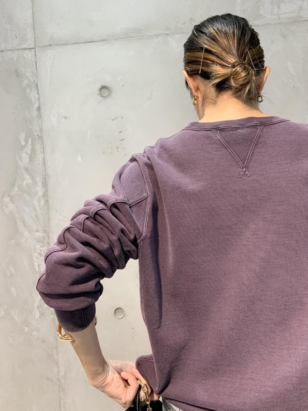 パープル系のスウェット、ブラック系のショルダーバッグ、グレー系のデニムパンツを着用したレディースの夏コーディネートの4枚目の写真