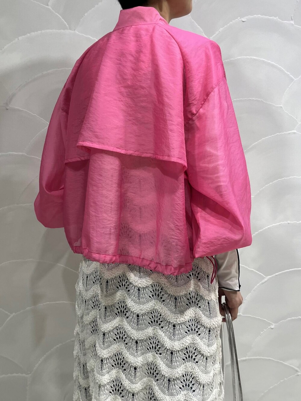 ピンク系のブルゾン、ホワイト系のワンピース、シルバー系のショルダーバッグを着用したレディースの春コーディネートの4枚目の写真