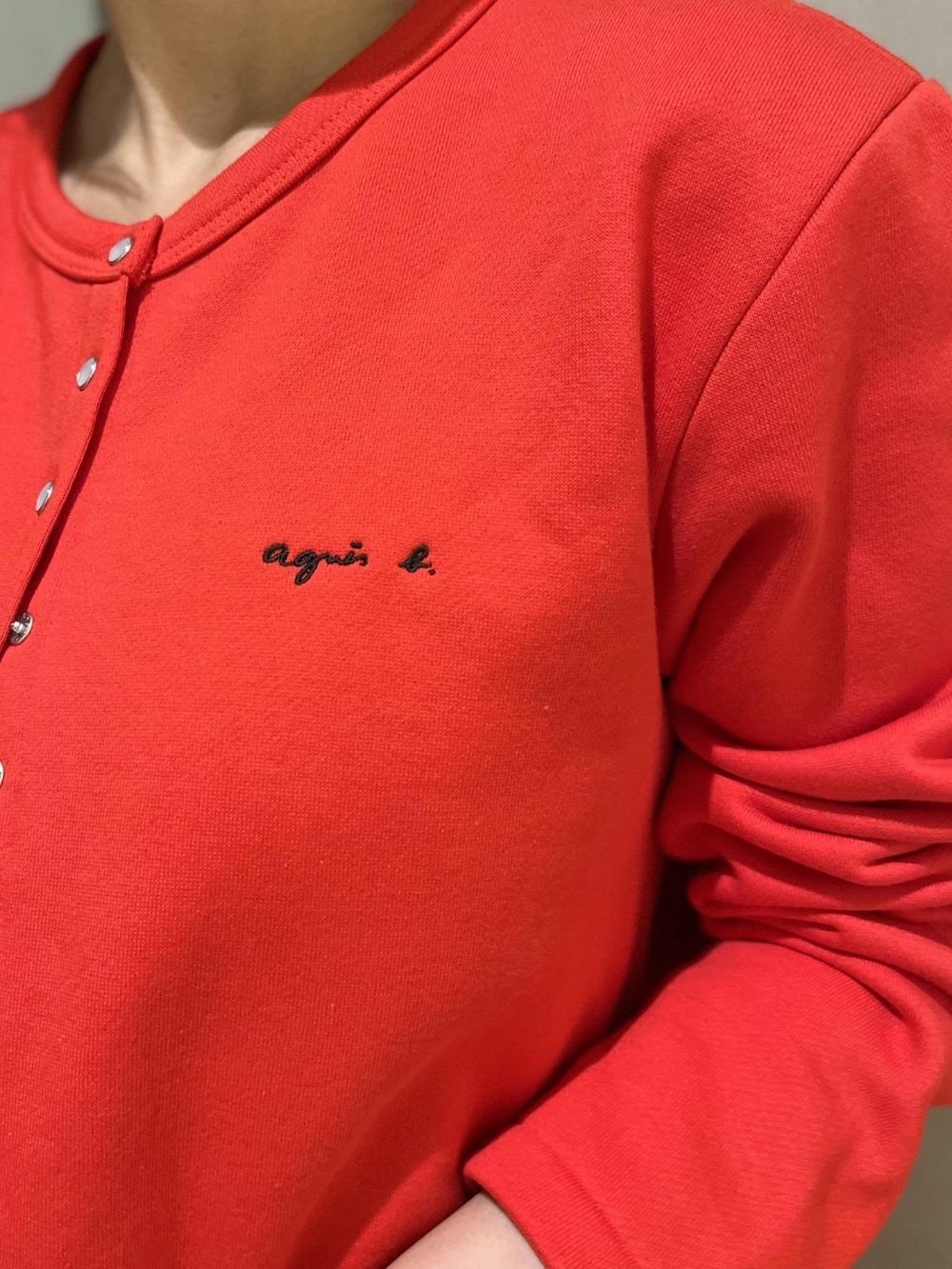 ホワイト系のローファー、レッド系のカーディガン/ボレロ、ブラック系のワンピースを着用したレディースの夏コーディネートの2枚目の写真