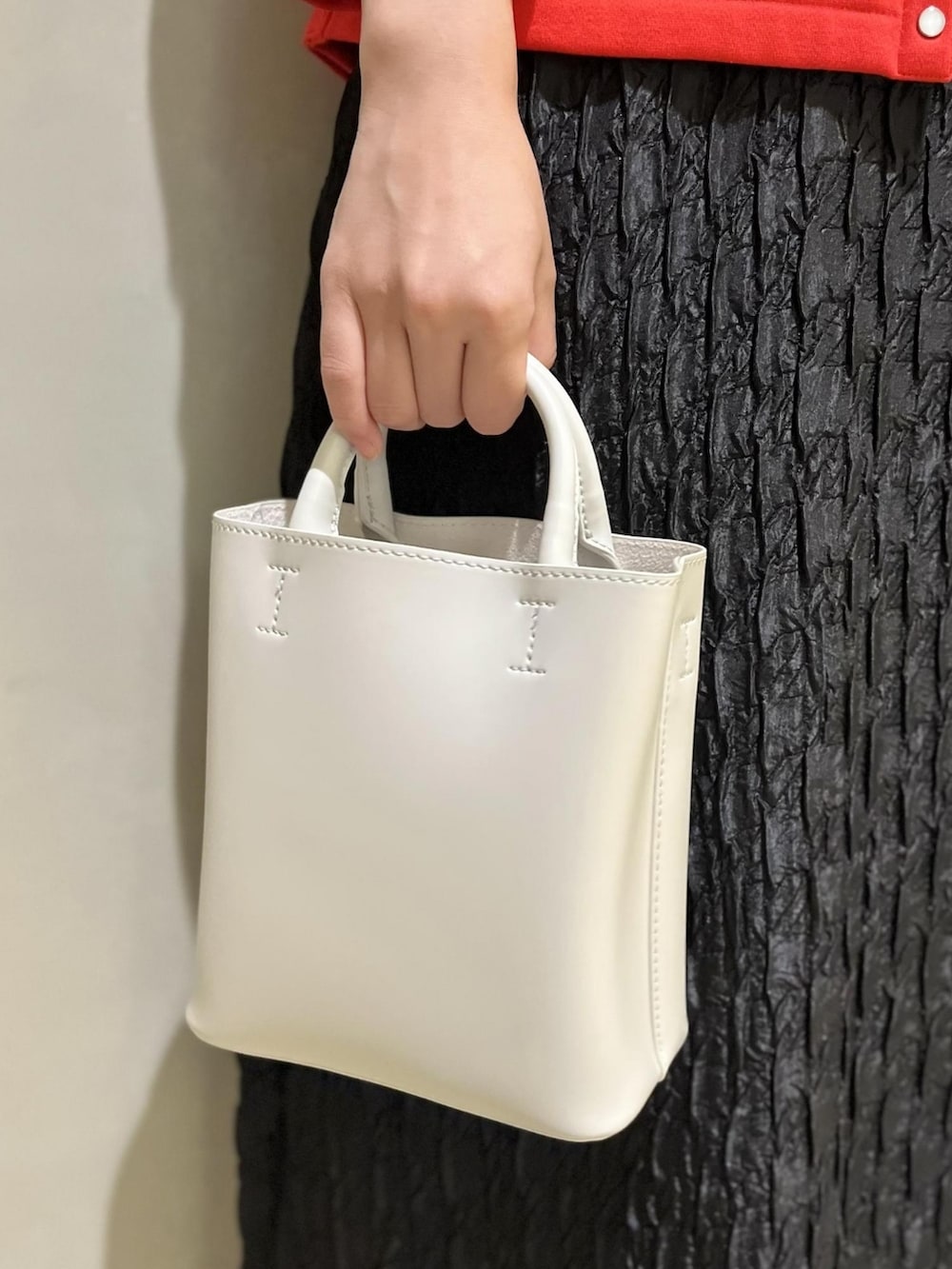 ホワイト系のローファー、レッド系のカーディガン/ボレロ、ブラック系のワンピースを着用したレディースの夏コーディネートの4枚目の写真