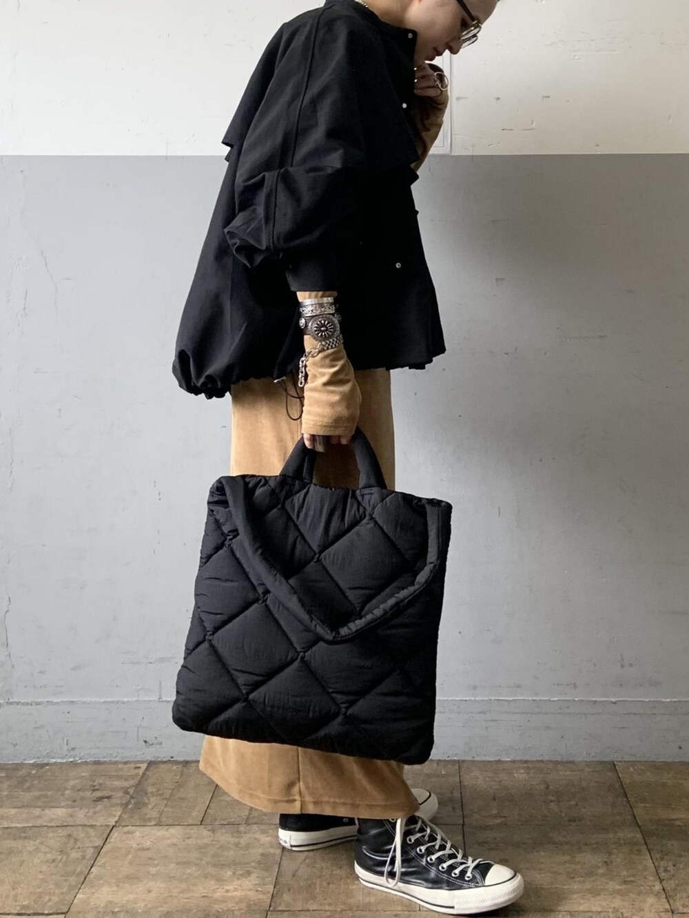 ブラック系のブルゾン、ベージュ系のワンピース、ブラック系のトートバッグを着用したレディースの秋コーディネートの5枚目の写真