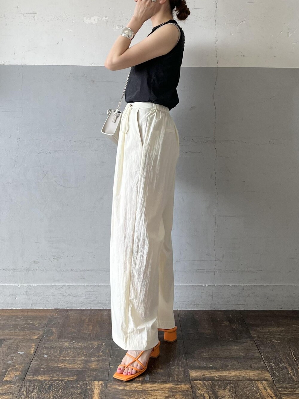 ブラック系のタンクトップ、グレー系のショルダーバッグ、ホワイト系のその他パンツを着用したレディースの夏コーディネートの2枚目の写真