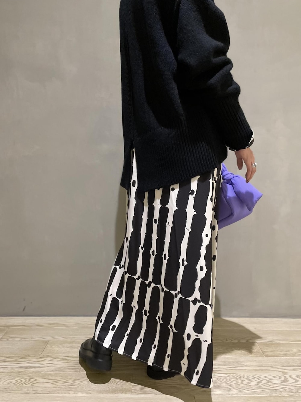 ブラック系のニット/セーター、パープル系のハンドバッグ、ブラック系のワンピースを着用したレディースの夏コーディネートの5枚目の写真