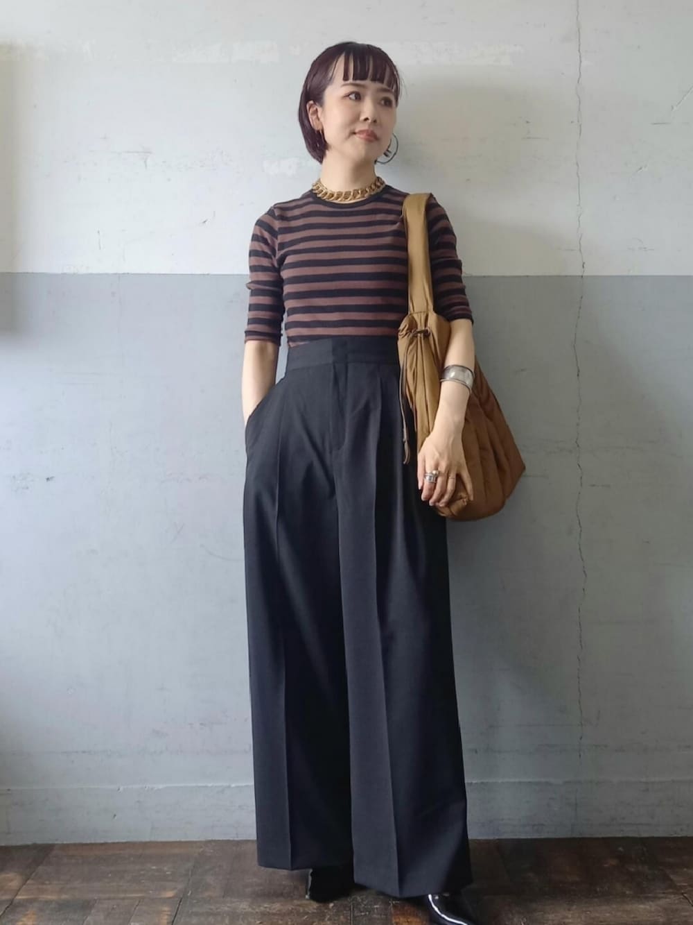 ブラック系のパンプス、ブラック系のスラックス、ブラウン系のTシャツ/カットソーを着用したレディースの秋コーディネートの2枚目の写真