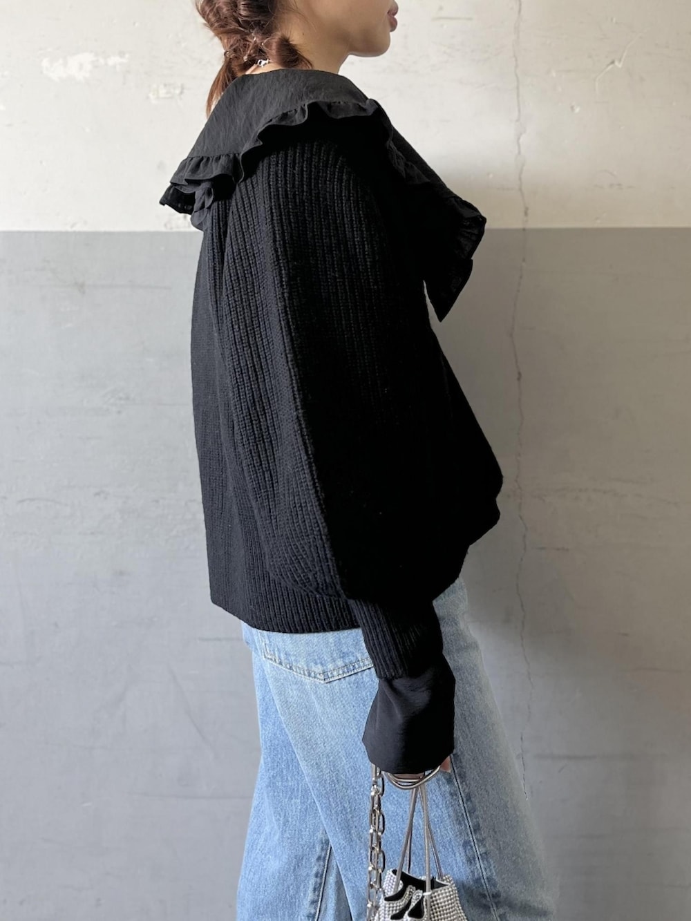 ブラック系のカーディガン/ボレロ、ブラック系のシャツ/ブラウス、ブルー系のデニムパンツを着用したレディースの冬コーディネートの5枚目の写真