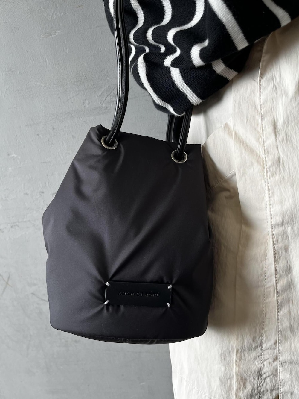 ブラック系のニット/セーター、ブラック系のショルダーバッグ、ホワイト系のその他パンツを着用したレディースの冬コーディネートの4枚目の写真
