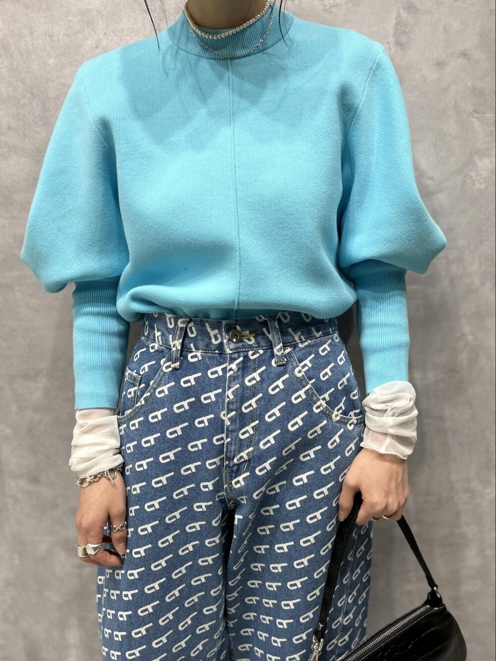 ブルー系のニット/セーター、ホワイト系のTシャツ/カットソー、ブルー系のデニムパンツを着用したレディースの冬コーディネートの3枚目の写真