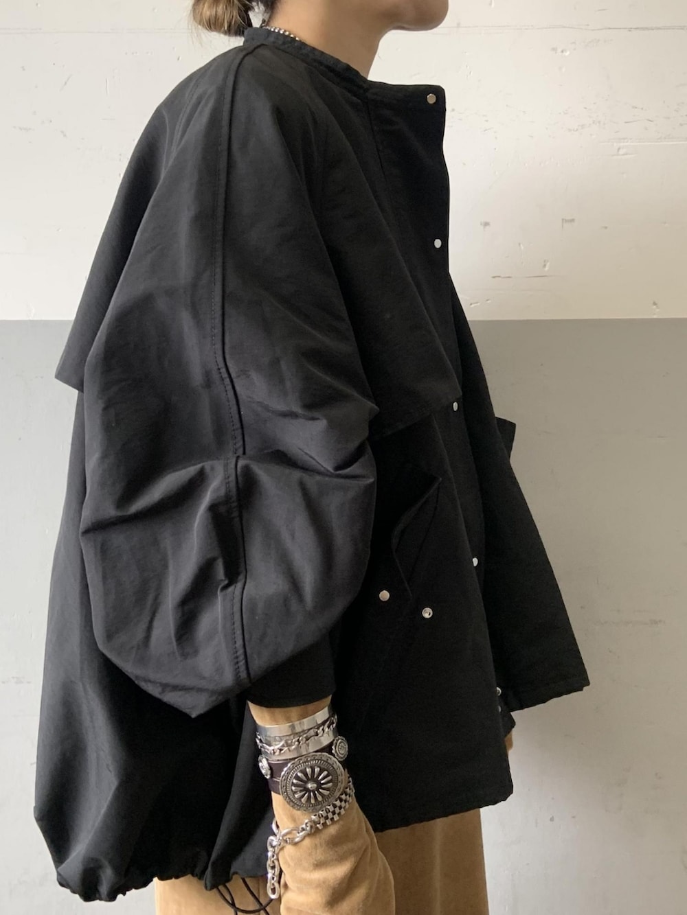 ブラック系のブルゾン、ベージュ系のワンピース、ブラック系のトートバッグを着用したレディースの秋コーディネートの4枚目の写真