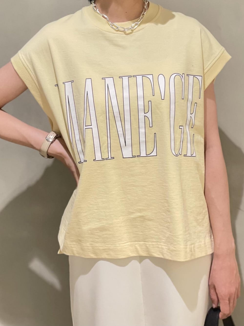 ホワイト系のワンピース、ベージュ系のTシャツ/カットソー、ブラック系のサンダルを着用したレディースの夏コーディネートの2枚目の写真