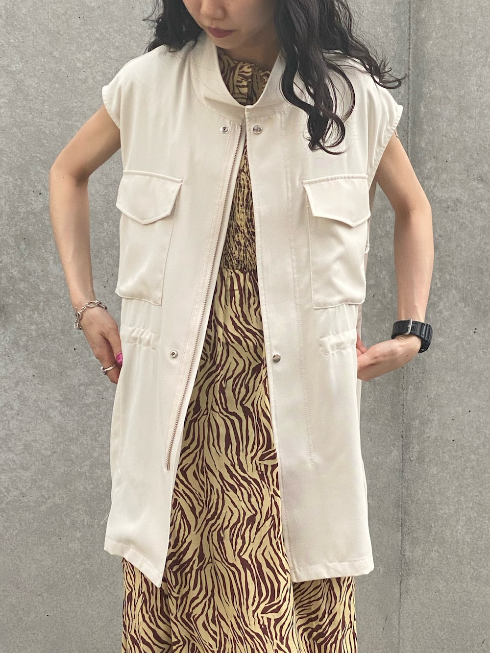 グリーン系のベスト、ホワイト系のサンダルを着用したレディースの夏コーディネートの2枚目の写真