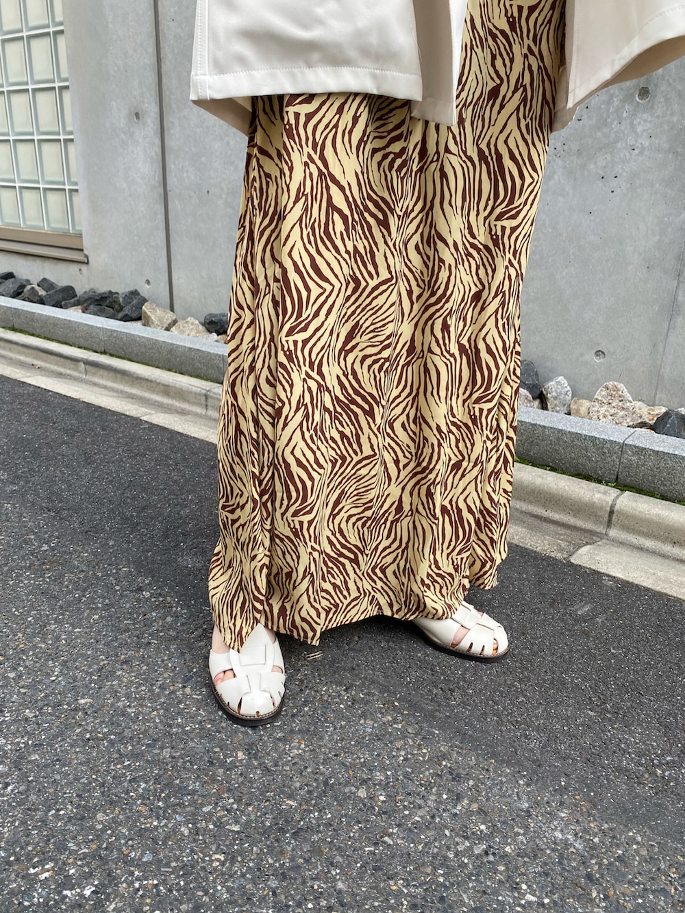 グリーン系のベスト、ホワイト系のサンダルを着用したレディースの夏コーディネートの3枚目の写真