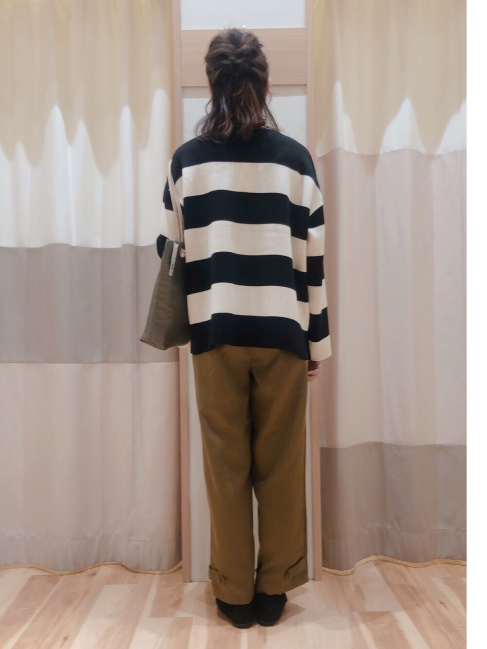 グリーン系のその他パンツ、ブラック系のニット/セーター、ブラック系のモカシン/デッキシューズを着用したレディースの秋コーディネートの2枚目の写真
