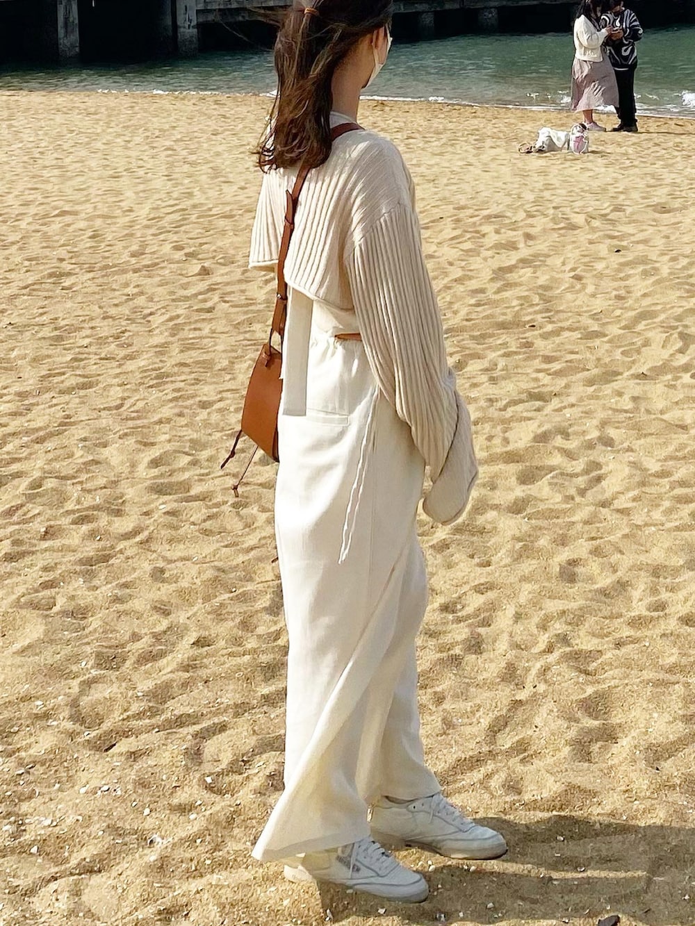 ホワイト系のシャツ/ブラウス、オレンジ系のTシャツ/カットソー、ホワイト系のサロペット/オーバーオールを着用したレディースの春コーディネートの2枚目の写真