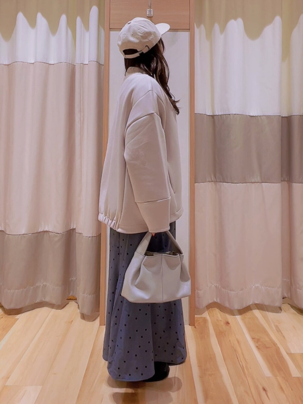 ブラック系のTシャツ/カットソー、グレー系のハンドバッグ、ホワイト系のノーカラージャケットを着用したレディースの秋コーディネートの4枚目の写真