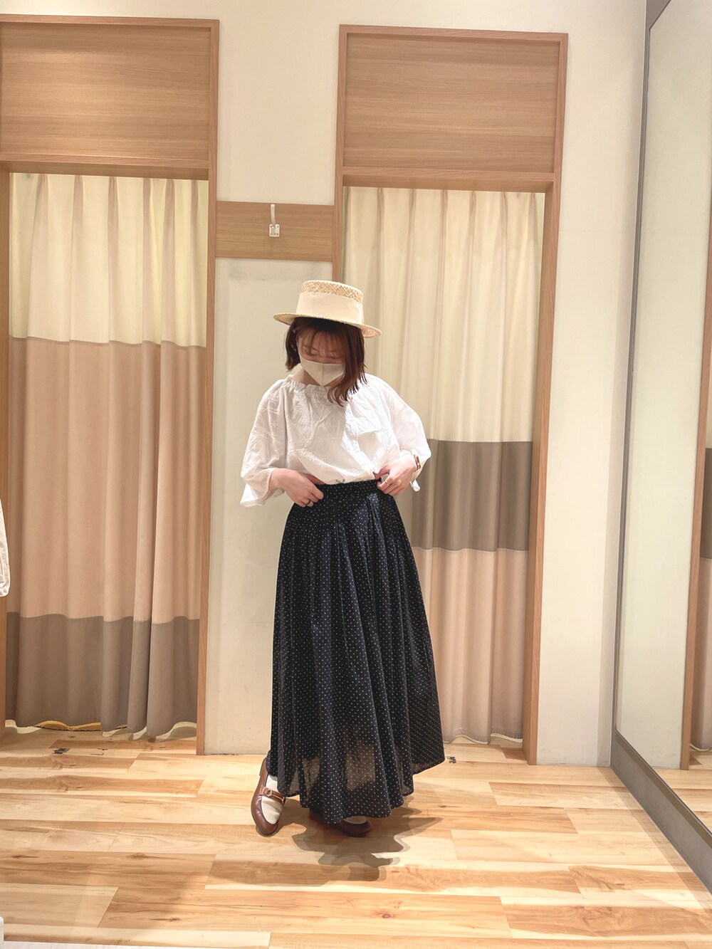 ホワイト系のシャツ/ブラウス、ブラック系のスカート、ベージュ系の帽子を着用したレディースの春コーディネートの2枚目の写真