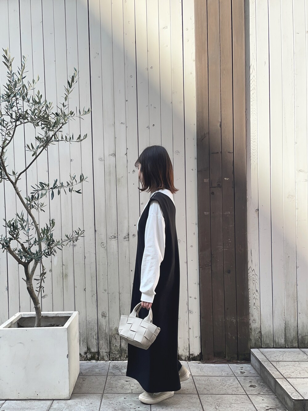ブラック系のワンピース/ドレス、ホワイト系のTシャツ/カットソー、ホワイト系のバッグを着用したレディースの春コーディネートの2枚目の写真