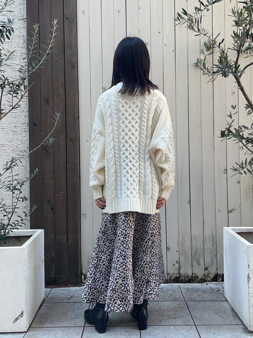 ホワイト系のニット/セーター、ホワイト系のTシャツ/カットソー、ブラック系のスカートを着用したレディースの冬コーディネートの3枚目の写真