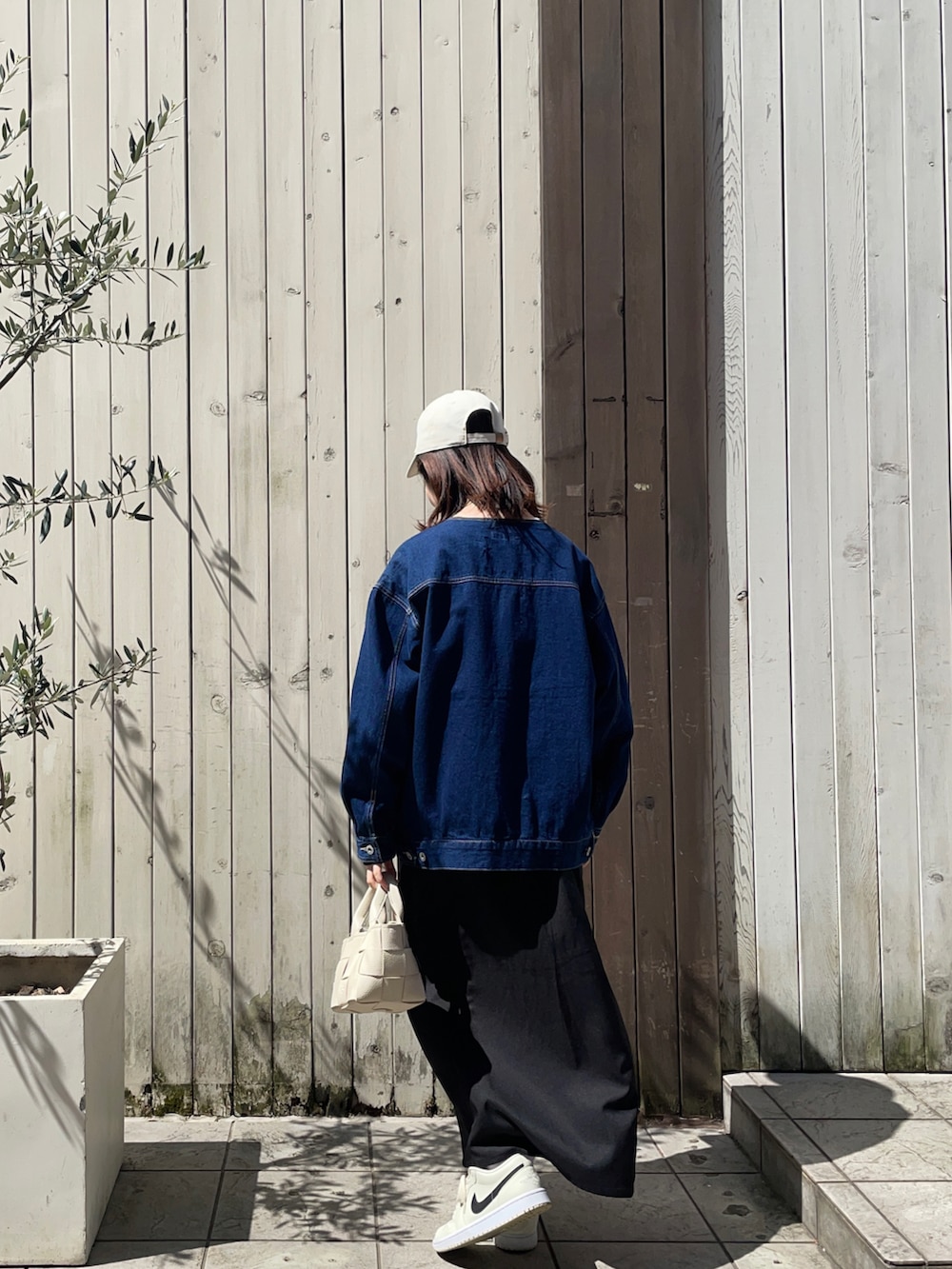 ブルー系のジャケット/アウター、ブラック系のワンピース、ホワイト系のTシャツ/カットソーを着用したレディースの春コーディネートの2枚目の写真