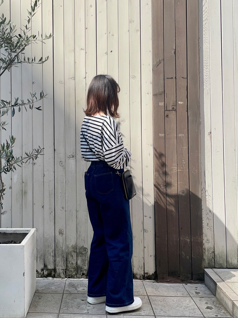 ブラック系のショルダーバッグ、ホワイト系のTシャツ/カットソー、ブルー系のその他パンツを着用したレディースの春コーディネートの2枚目の写真