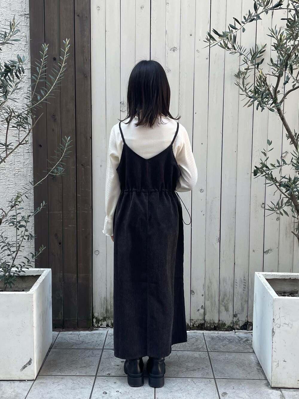 ホワイト系のTシャツ/カットソー、グレー系のワンピース、ブラック系のブーツを着用したレディースの冬コーディネートの3枚目の写真