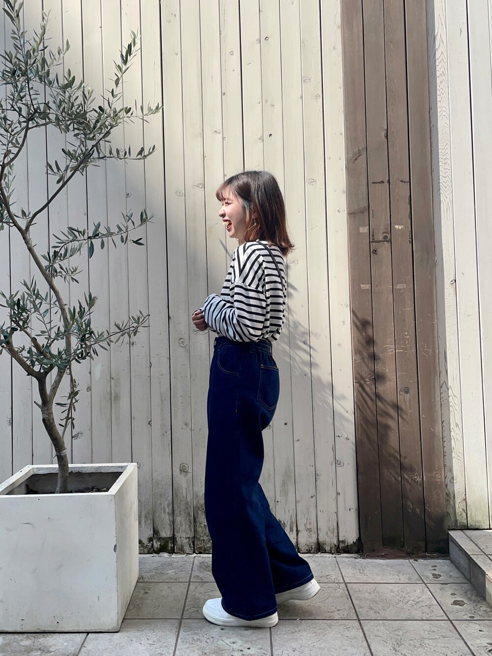 ブラック系のショルダーバッグ、ホワイト系のTシャツ/カットソー、ブルー系のその他パンツを着用したレディースの春コーディネートの3枚目の写真