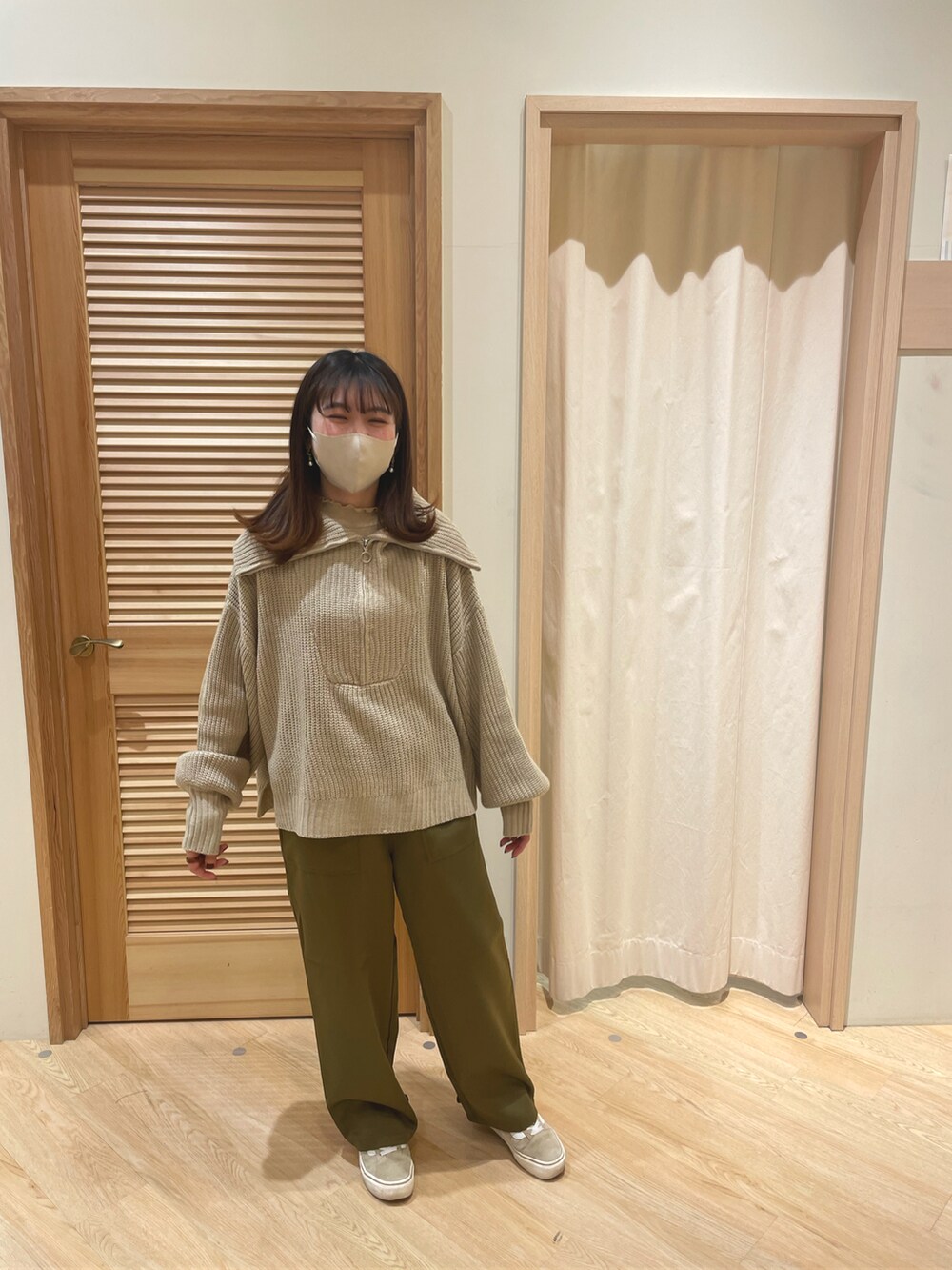 ベージュ系のニット/セーター、グリーン系のパンツ、ベージュ系のTシャツ/カットソーを着用したレディースの冬コーディネートの2枚目の写真